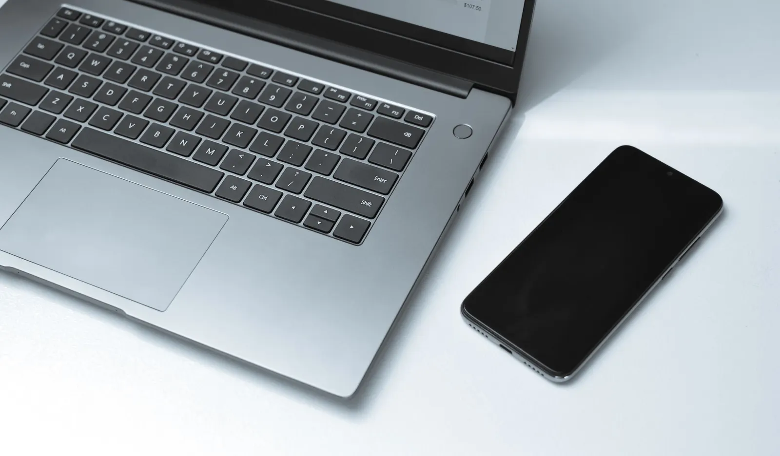 A laptop and smartphone on a clean modern office desk